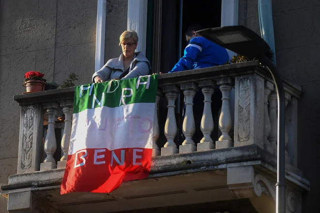 Vse bo še dobro, je zapisano na zastavi na enem izmed milanskih balkonov. FOTO: Daniele Mascolo/Reuters