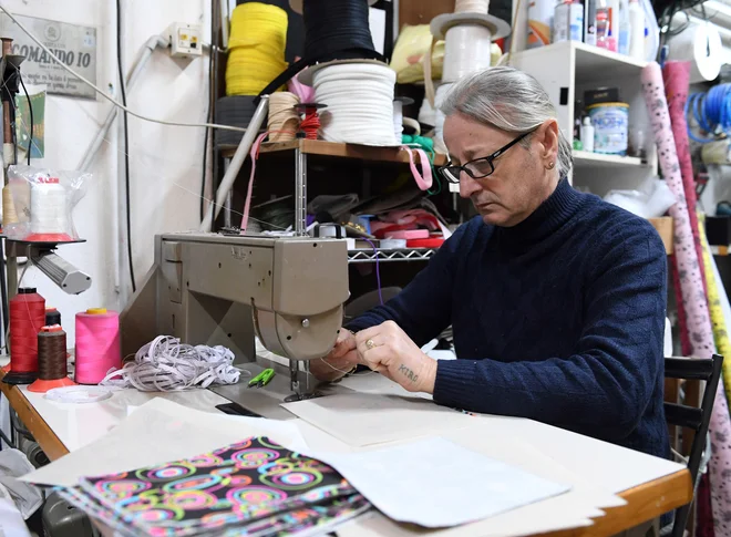 Lastnik družinske šivalnice Adolfo Lettieri šiva tudi med krizo. Zdaj šiva zaščitne maske in jih deli brezplačno. FOTO: Jennifer Lorenzini/Reuters