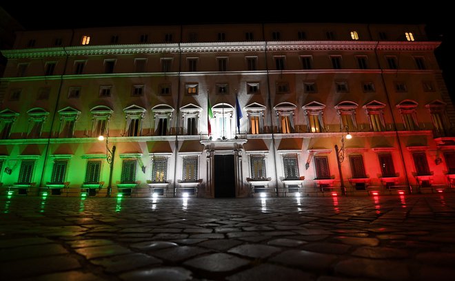 Rimska palača Chigi, sedež premiera Giuseppeja Conteja, je med krizo v barvah italijanske zastave. FOTO: Alberto Lingria/Reuters