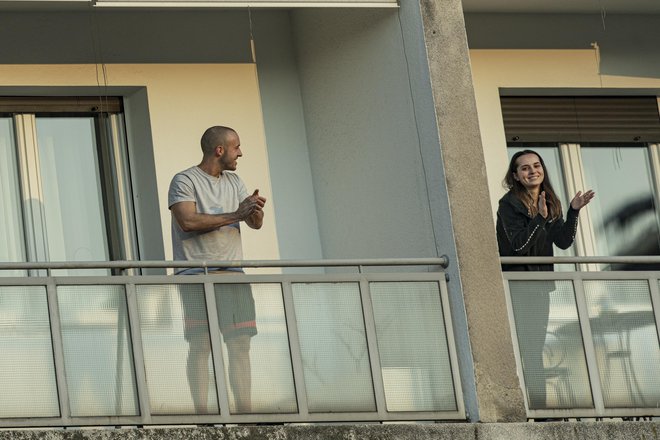 Ljudje ploskajo na balkonih v podporo zdravstvenim delavcem. FOTO: Voranc Vogel/Delo