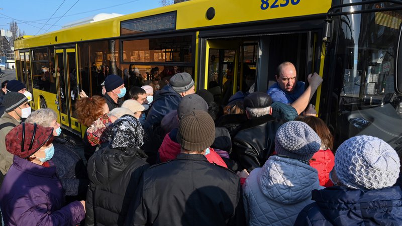 Fotografija: Desetine ljudi čaka na avtobusnem postajališču v Kijevu, potem ko je Ukrajina omejila število potnikov, ki se vozijo na avtobusu, na maksimalno 10 naenkrat, kot ukrep proti širjenju koronavirusa. FOTO: Genya Savilov/Afp
 