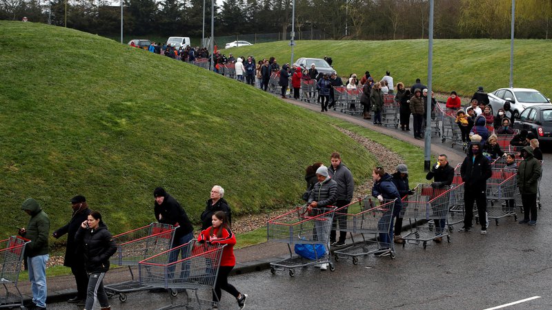 Fotografija: Ljudje čakajo v dolgi vrsti pred trgovino Costco v Watfordu, saj se širjenje koronavirusa v Veliki Britaniji nadaljuje. FOTO: Paul Childs/Reuters