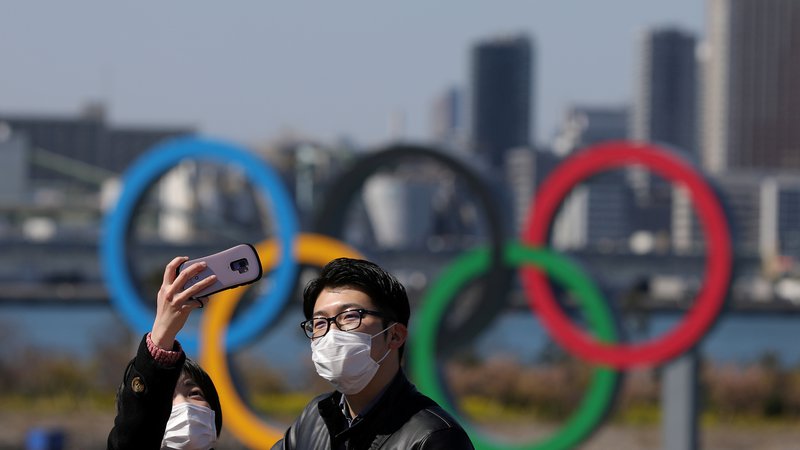 Fotografija: Japonci se slikajo s petimi olimpijskimi krogi z zaščitnimi maskami. FOTO: Reuters