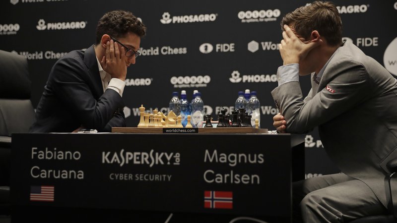 Fotografija: Magnus Carlsen (desno) v dvoboju za naslov svetovnega prvaka v Londonu s Fabianom Caruano. FOTO: Matt Dunham/AP