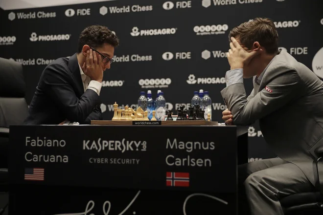Magnus Carlsen (desno) v dvoboju za naslov svetovnega prvaka v Londonu s Fabianom Caruano. FOTO: Matt Dunham/AP