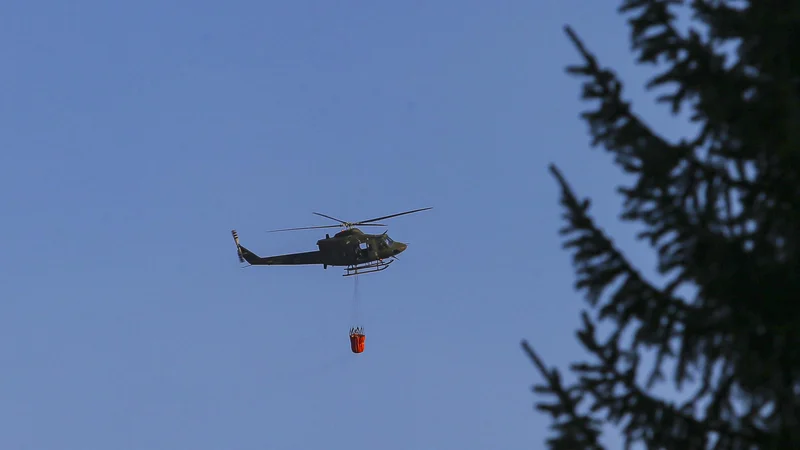 Fotografija: Petkov osmi požar na Šentviškem hribu so gasili tudi s helikopterjem Slovenske vojske. FOTO: Jože Suhadolnik/Delo