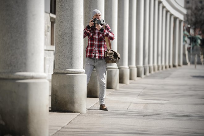 Delovi fotoreporterji so tudi v teh dneh na terenu. Na fotografiji Blaž Samec med fotografiranjem praznih ljubljanskih ulic.<br />
FOTO: Uroš Hočevar