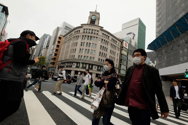 Prebivalci Tokia uporabljajo zaščitne maske. FOTO: AFP