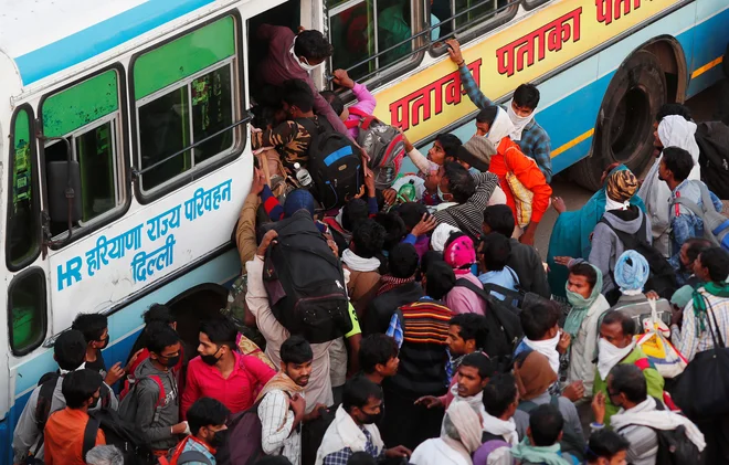 Nekaterim indijskim državam in območnim vladam je uspelo organizirati avtobusni prevoz za del migrantov iz največjih središč, večina pa jih je ostala tam, kjer so bili trenutno. Foto: Reuters