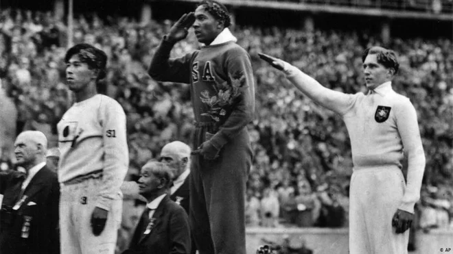 Jesse Owens (v sredini) po olimpijski zmagi v skoku v daljavo, desno srebrni Nemec Luz Long. FOTO: Arhiv MOK