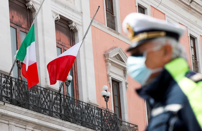 V Italiji so se z minuto molka ter zastavami, spuščenimi na pol droga, spomnili žrtev koronavirusne bolezni 19. FOTO: Alessandro Garofalo/Reuters