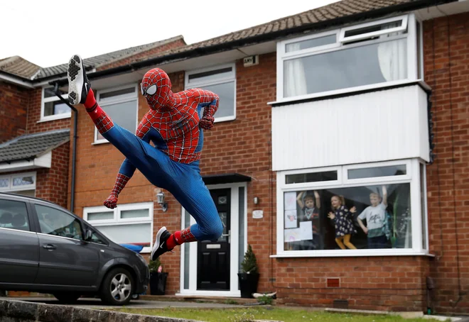 V Stockportu Anglež Jason Baird oblečen v Spidermana med vsakodnevno vadbo razveseljuje lokalne otroke. FOTO: Phil Noble/Reuters<br />
