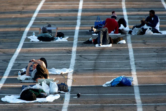 V Las Vegasu so za brezdomce »poskrbeli« tako, da so na betonska tla parkišča narisali kakšna je varna razdalja na kateri lahko spijo. FOTO: Steve Marcus/Reuters