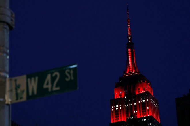 Newyorški Empire State Building je v poklon zdravstvenim delavcem osvetljen z rdečo barvo. FOTO: Andrew Kelly/Reuters