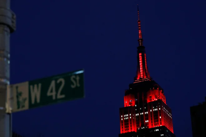 Newyorški Empire State Building je v poklon zdravstvenim delavcem osvetljen z rdečo barvo. FOTO: Andrew Kelly/Reuters