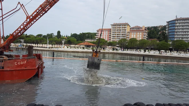 Tako so včeraj še kalili vodo na eni najbolj urejenih plaž v kraju. A so popoldne delavci začeli pospravljati stroje. FOTO: Boris Šuligoj