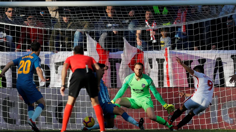 Fotografija: Jan Oblak (v zelenem) je bil ob prejetem golu nemočen; takole je streljal na njegova vrata Wissam Ben Yedder. FOTO: Reuters