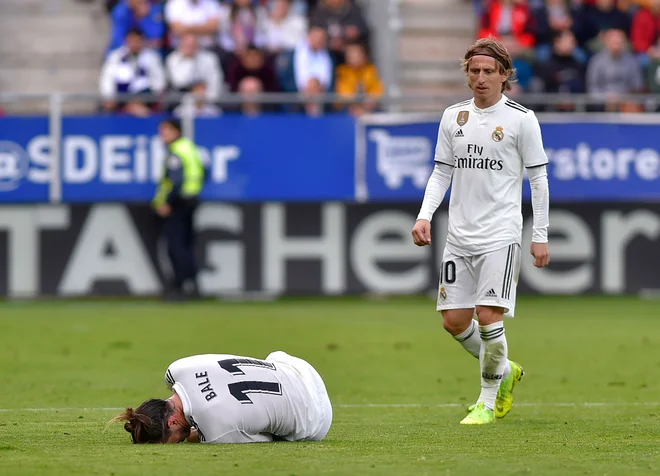 Gareth Bale (na tleh) naj bi izpustil današnji derbi Ajaxa in madridskega Reala, Luka Modrić (desno) bo poveljeval zvezni vrsti evropskih prvakov. FOTO: AFP