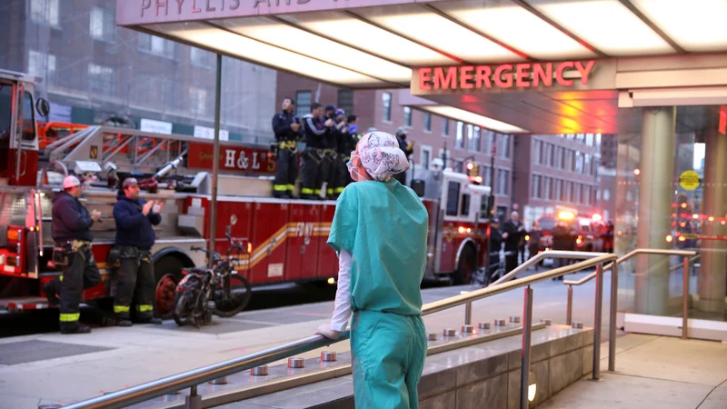 Fotografija: Gasilci se z aplavzom zahvaljujejo naporom zdravstvenega osebja na pavilijonu Phyllis And William Mack na Manhattanu v New Yorku, kjer so razmere na področju koronavirusa zadnje dni zelo, zelo težke. Foto Reuters