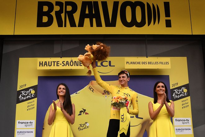 Italy's Giulio Ciccone (C) celebrates his overall leader's yellow jersey on the podium of the sixth stage of the 106th edition of the Tour de France cycling race between Mulhouse and La Planche des Belles Filles, in La Planche des Belles Filles on July 11, 2019. (Photo by JEFF PACHOUD / AFP)
