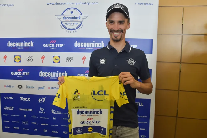 Francoz Julian Alaphilippe z rumeno majico razveseljuje rojake. FOTO: AFP