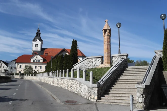 Baročna župnijska cerkev sv. Petra v Komendi, ob stopnišču pri vhodu na kopališče gotsko znamenje z malteškim križem. Foto: Dejan Javornik