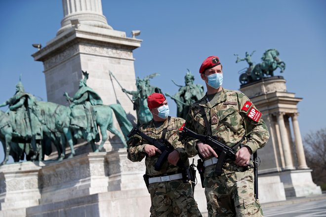 Žerdin je opozoril tudi na pomenljivo fotografijo, ki jo je <em>Delo </em>objavilo ob odprtem pismu: »Gre za fotografijo z enega od znamenitih trgov v Budimpešti, na katerem sta do zob oborožena vojaka s puškami, maskami, skratka, gre za jasno militarizacijo boja proti epidemiji in to na najbolj prestižnem mestu same Budimpešte.« FOTO: Bernadett Szabo/Reuters
