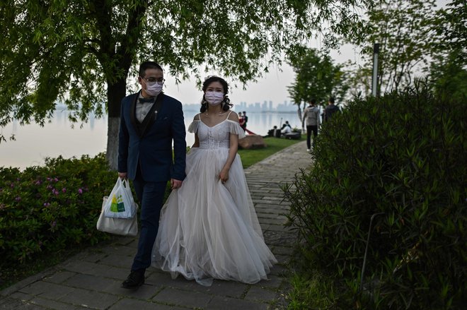 Veliko parov je iz karantene pohitelo na poročni urad, datumi s srečnimi številkami niso bili pomembni. FOTO: AFP