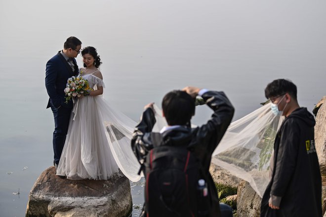 Studii, ki so se specializirali za poročne fotografije, so se morali prilagoditi novi stvarnosti. FOTO: AFP