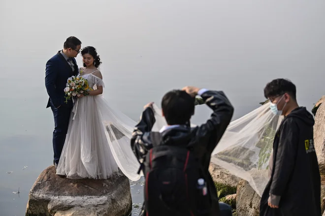 Studii, ki so se specializirali za poročne fotografije, so se morali prilagoditi novi stvarnosti. FOTO: AFP