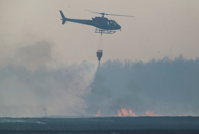 Gasilci si pri gašenju pomagajo tudi s helikopterji. FOTO: Agnieszka Sadowska/Agencja Gazeta via Reuters