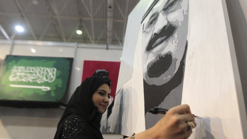 Fotografija: Ženska ustvarja portret kralja Abdulaha. FOTO: Faisal Al Nasser/Reuters