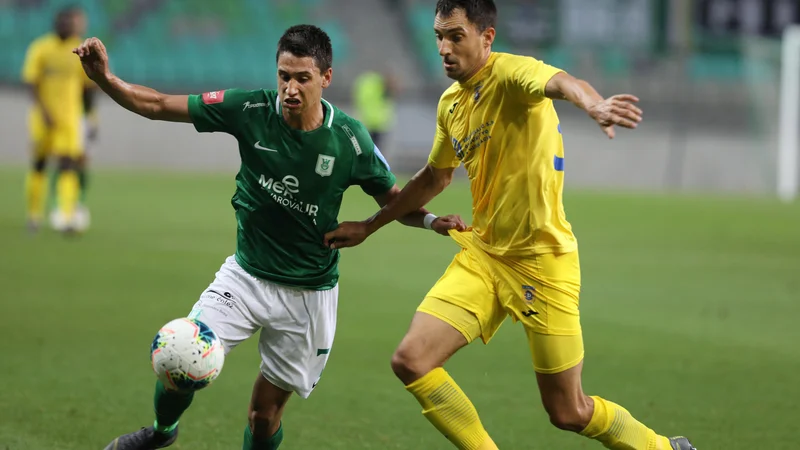 Fotografija: Olimpijin napadalec Luka Menalo (levo) in domžalski branilec Branko Ilić bi lahko bila med nogometaši, ki ne bodo dokončali morebitnega podaljšanega prvenstva v julij. FOTO: Voranc Vogel/Delo