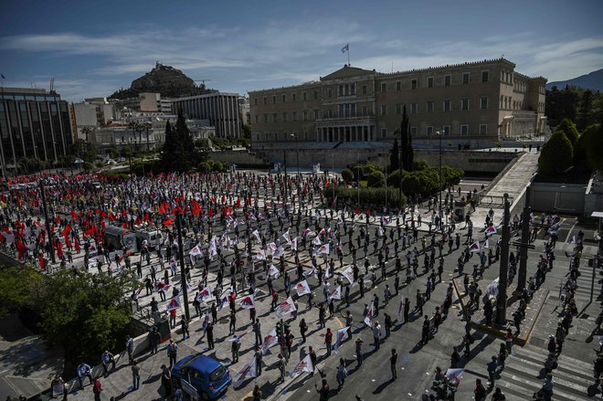 Grški delavci in študentje pred parlamentom v Atenah protestirajo z maskami in držeč varno medsebojno razdaljo. FOTO: Aris Messinis/Afp
