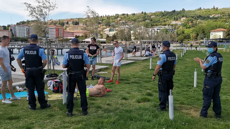 Fotografija: Policisti čistijo portoroško plažo. FOTO: Boris Šuligoj