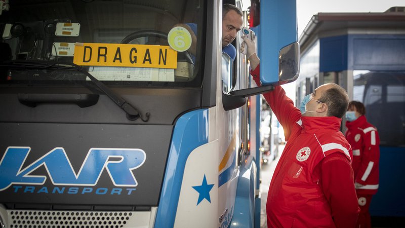 Fotografija: Delavci Rdečega križa in policija na mejnih prehodih izvaja merjenje temperature. FOTO: Voranc Vogel/Delo