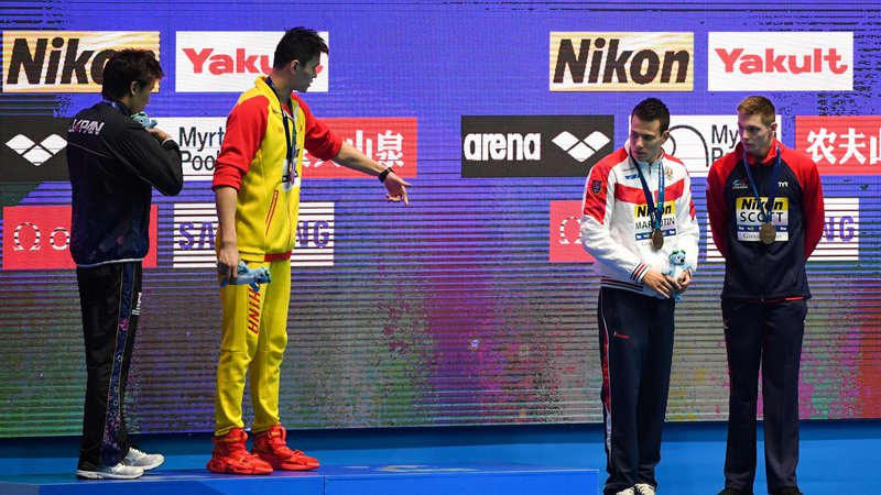 Fotografija: Svetovni prvak na 200 m prosto Sun Yang (drugi z leve), ob katerem je srebrni Japonec Macumoto, je na najvišjo stopničko povabil Rusa Maljutina in Britanca Scotta, ki sta si delila tretje mesto. Slednji ga je zavrnil. FOTO: AFP