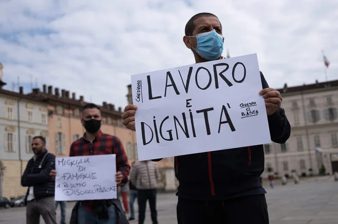Delo in dostojanstvo, so zahtevali protestniki v Torinu. Pandemija koronavirusa bo imela močne gospodarske in socialne posledice.&nbsp; FOTO: Marco Bertorello/AFP
