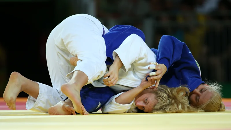 Fotografija: Ana Velenšek (v modrem kimonu) je še zmeraj v stiku z ameriško šampionko Kayla Harrison (levo), zdaj vzhajajočo zvezdnico v mešanih borilnih športih (MMA), ki ji je pred tremi leti na olimpijskih igrah v Riu de Janeiru zadala edini poaz. FOTO: Reuters