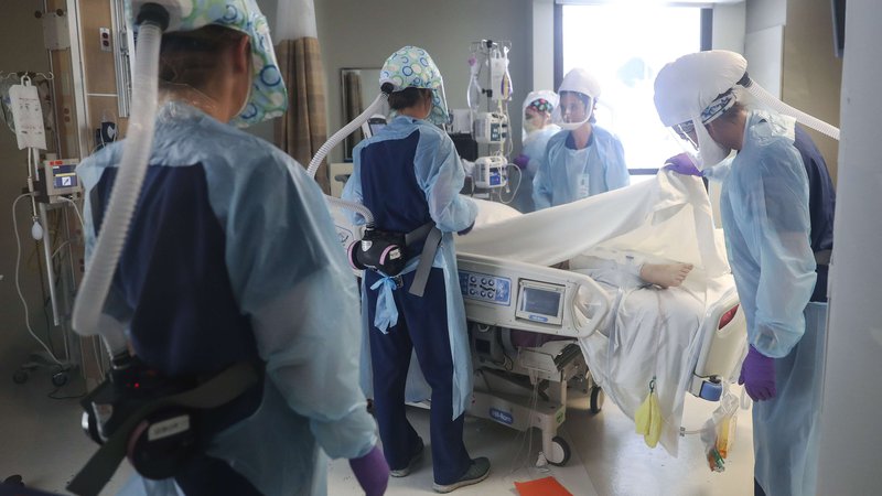 Fotografija: Zdravniki na oddelku intenzivne nege v bolnišnici v ameriškem San Diegu skrbijo za bolnike z zapletenim potekom bolezni covid-19. FOTO: Mario Tama/AFP