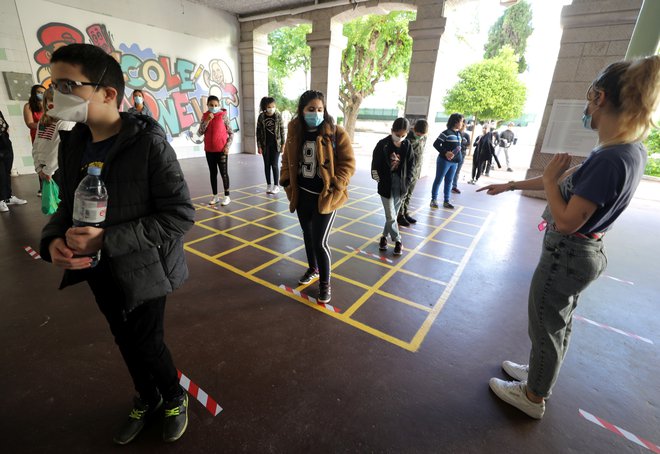Nov način prihajanja v šolo v Franciji. Podobno načrtujejo tudi pri nas – vstopanje posamično, primerna razdalja in za starejše od 12 let obvezne maske, razen v matičnem razredu. FOTO: Reuters