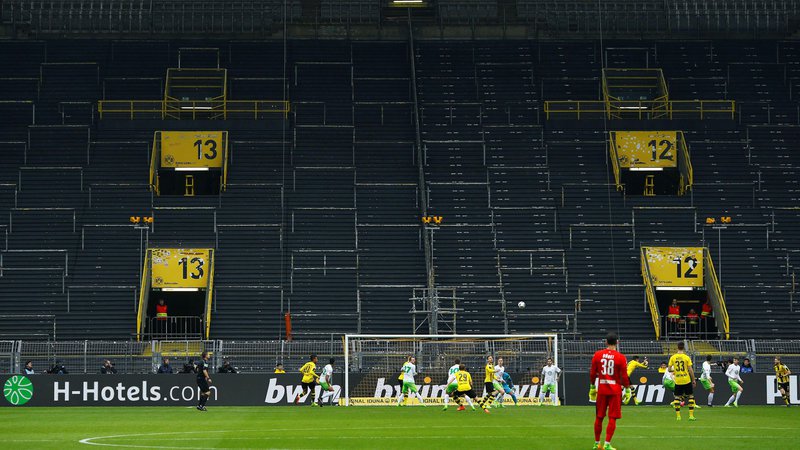 Fotografija: Takole sta pred tremi leti igrala Borussia in Wolfsburg zavoljo ene tekme prepovedi igranja pred navijači, ki je doletela Dortmundčane. Podoben prizor se obeta danes na porurskem derbiju. FOTO: Reuters