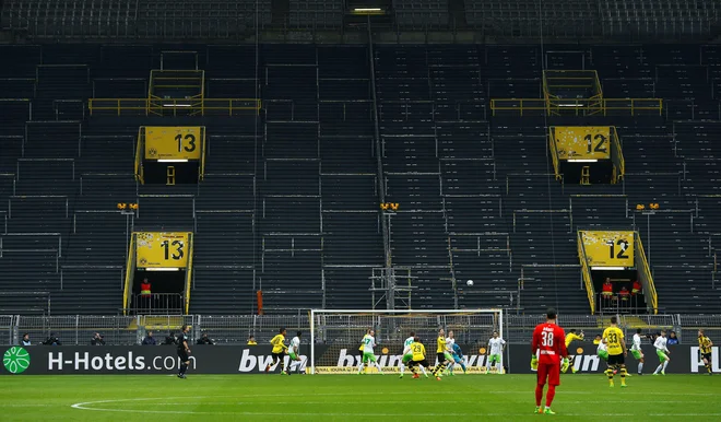 Takole sta pred tremi leti igrala Borussia in Wolfsburg zavoljo ene tekme prepovedi igranja pred navijači, ki je doletela Dortmundčane. Podoben prizor se obeta danes na porurskem derbiju. FOTO: Reuters