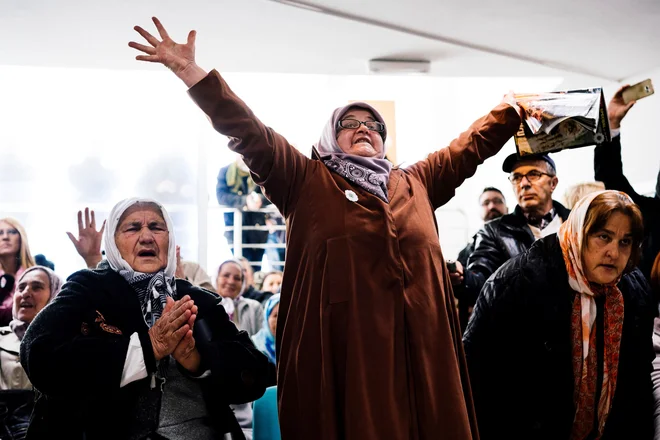 Svojci žrtev v spominskem parku Potočari spremljajo obsodbo vojaškega poveljnika bosanskih Srbov Ratka Mladića na haaškem sodišču za genocid v Srebrenici. FOTO: Dimitar Dilkoff/AFP
