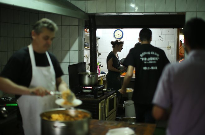 Begunci in migranti v nekdanji restavraciji, kjer jim prostovoljci pripravljajo tople obroke. FOTO: Jure Eržen
