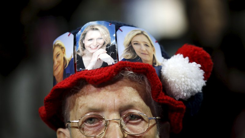 Fotografija: A supporter wears a cap with pictures of Marine Le Pen (R) and Marion Marechal-Le Pen (C), French National Front political party candidates for the second round of the regional elections in Marseille, France, December 9, 2015. REUTERS/Jean-Paul Pelissier       TPX IMAGES OF THE DAY      - GF10000260240