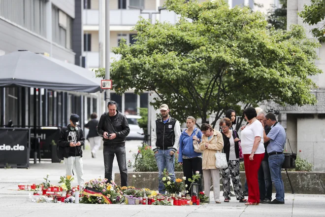 Ljudje stojijo ob cvetju in svečah, ki so jih položili po tem, ko so zabodli 35-letnega Nemca kubanskega rodu. FOTO: Foto Jan Woitas/AP