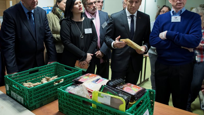 Fotografija: Predsednik Emmanuel Macron v človekljubni razdelilnici hrane Les Restos du Coeur. FOTO: Reuters
