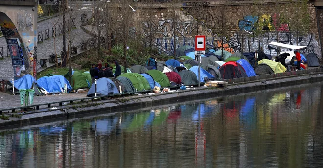 Macron je že za lani obljubil, kako ne bo več nihče prisiljen v životarjenje pod milim nebom, a je pretresljivih prizorov bivakiranja na prostem še vedno veliko, tako v Parizu kot drugod. FOTO: Gonzalo Fuentes/Reuters