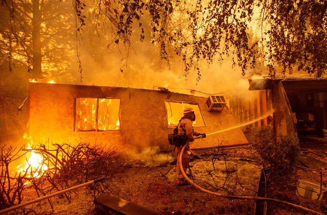 Gasilci se bojujejo s plameni, ki so zajeli apartmajsko poslopje v mestu Paradise, severno od Sacramenta. FOTO: Josh Edelson/AFP